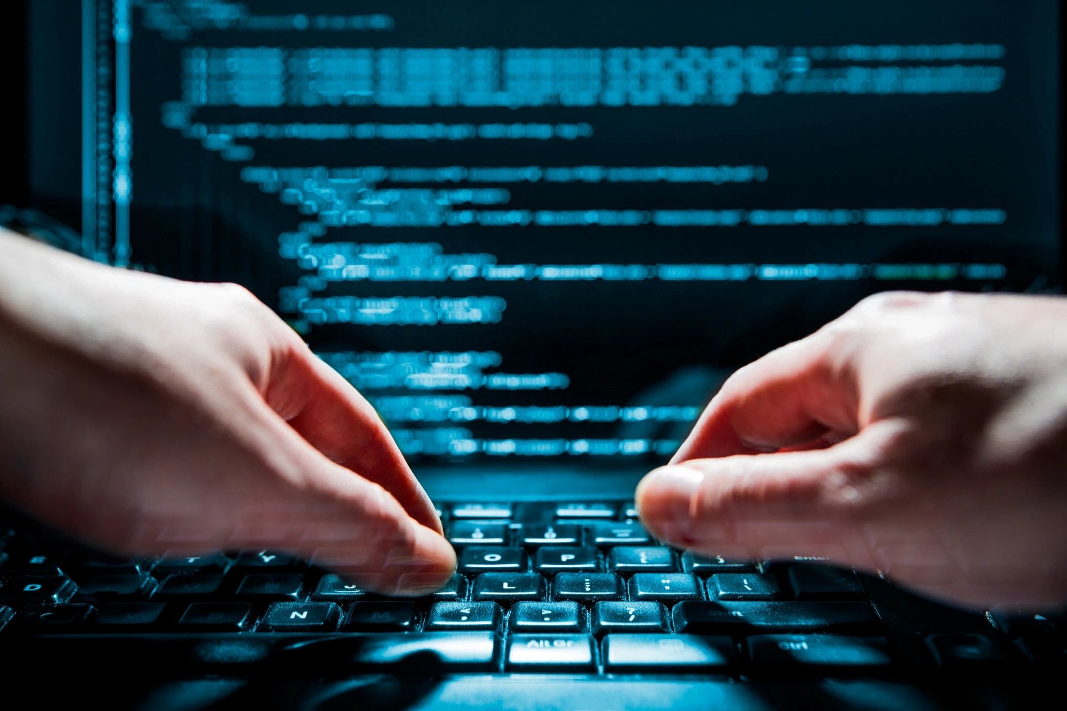 Hands typing code on a keyboard