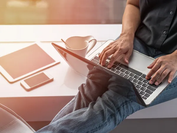 A person sitting at a table with a laptop.